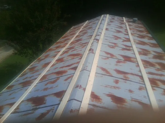 Rusted metal roof panels with new wood purlins before replacement — Storm Damage Roof Repair in Basin by Roofing Brothers