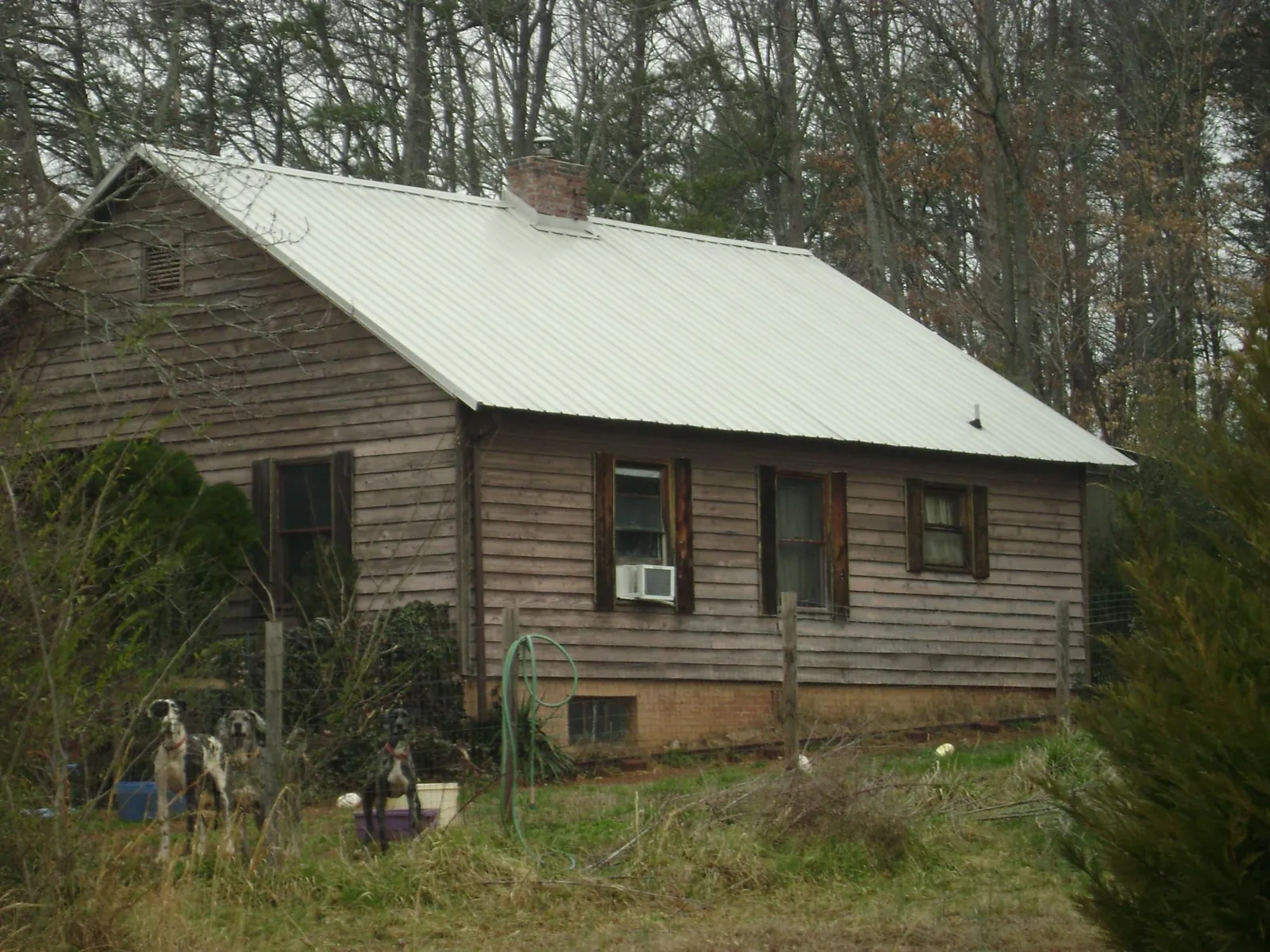 White metal roof on an old wood sided farmhouse, from a Metal Roof Installation job in Basin